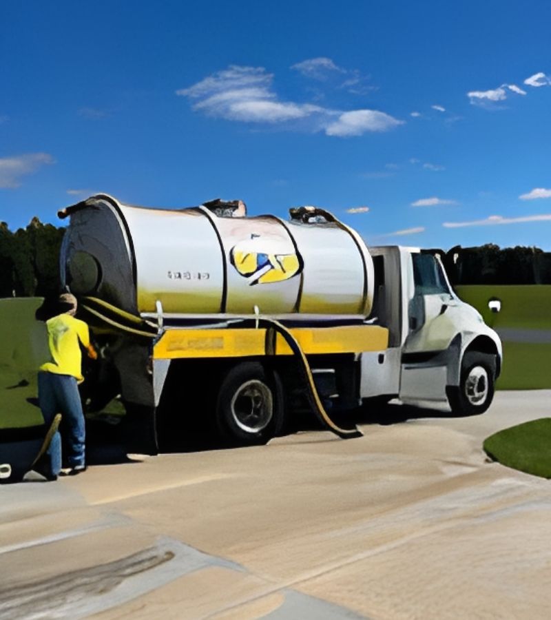 Septic vacuum truck with worker on driveway