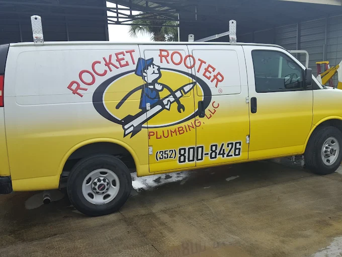Plumber van with a humorous 'Rocket Rooter' logo and contact number.
